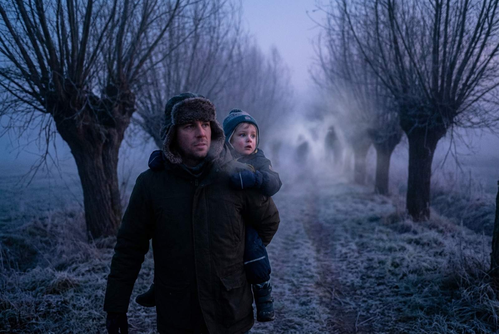 Ein Vater ist mit seinem Kind im Winter im Wald unterwegs